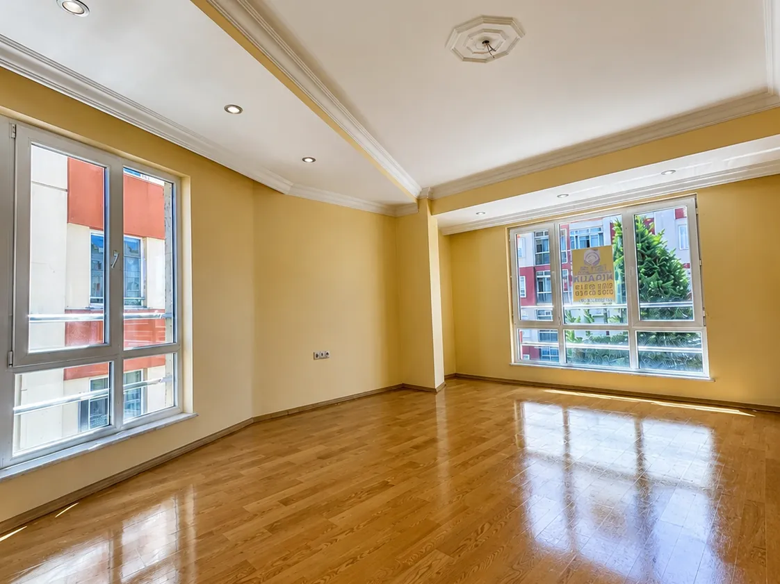 Kadıköy'de salon boyama sonrası — pürüzsüz sarı duvarlar ve cilalı parke